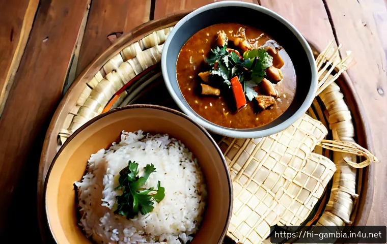 Home 17 감비아 전통 요리 - Photorealistic overhead food photography of a traditional Gambian meal on a rustic wooden table: a l...